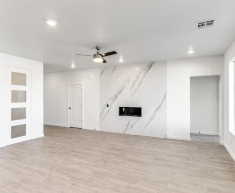 Freshly painted white living room with marble fireplace wall