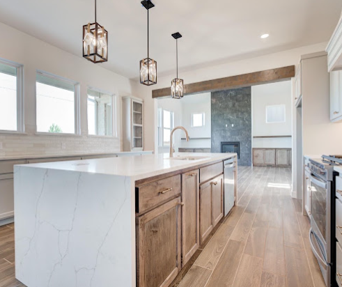 Bright kitchen with quartz waterfall island and stained wood cabinetry